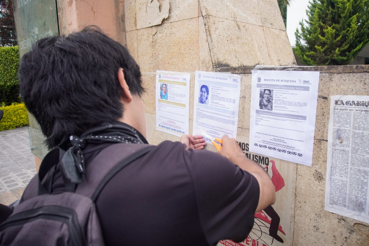 Estudiantes pegan el boletín de búsqueda de Hugo Alejandro Hernández Tello afuera de un comercio en Puebla | Foto: Agencia Enfoque